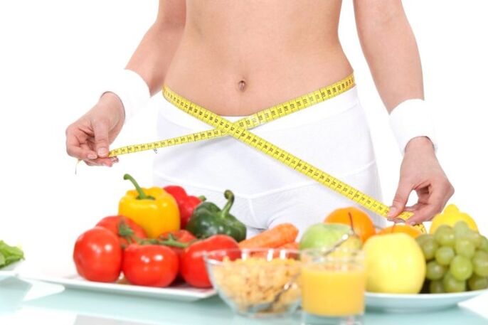 Girl measuring waist against grocery background